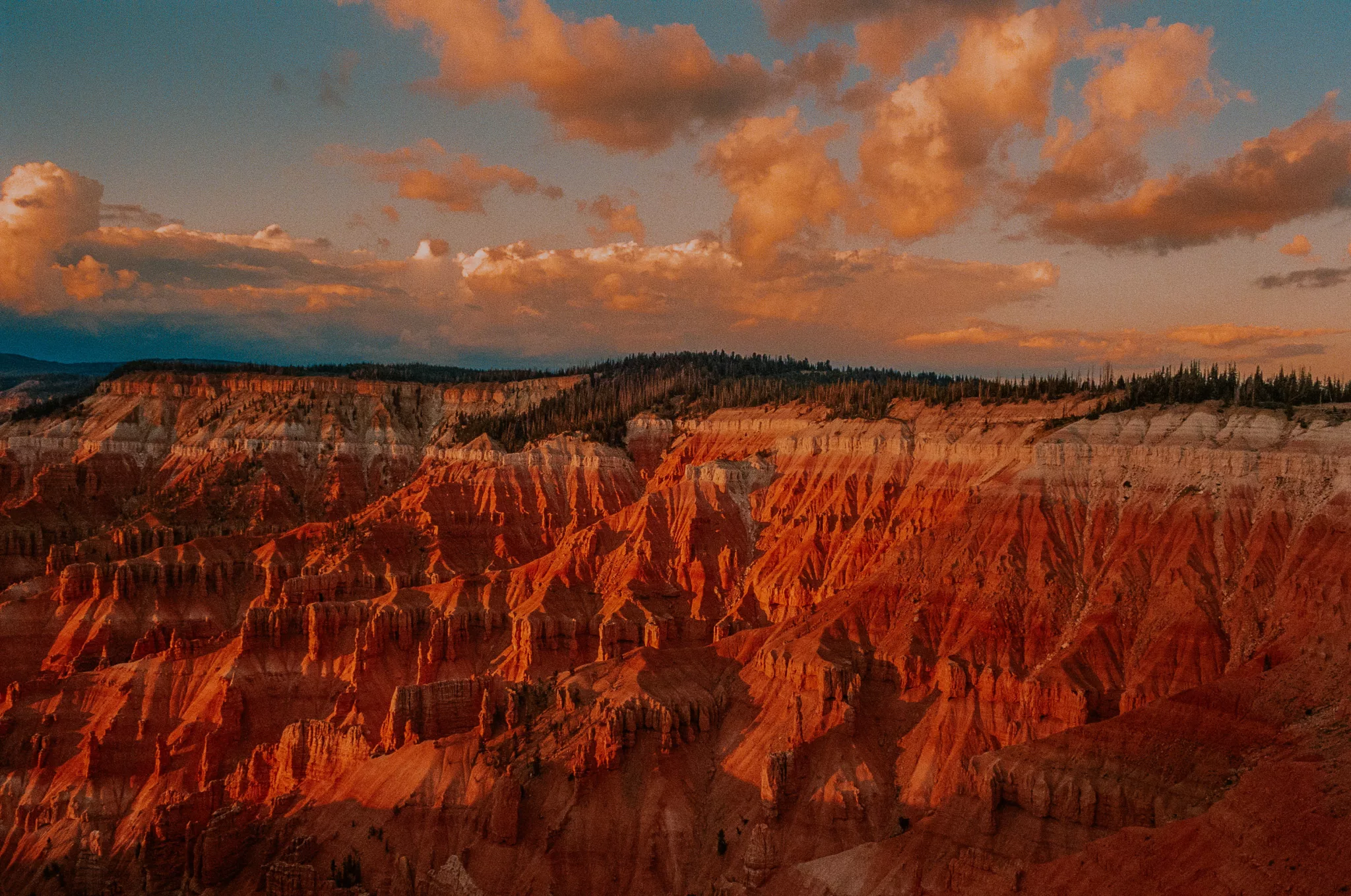 Red hoodoos glowing at golden hour under orange clouds