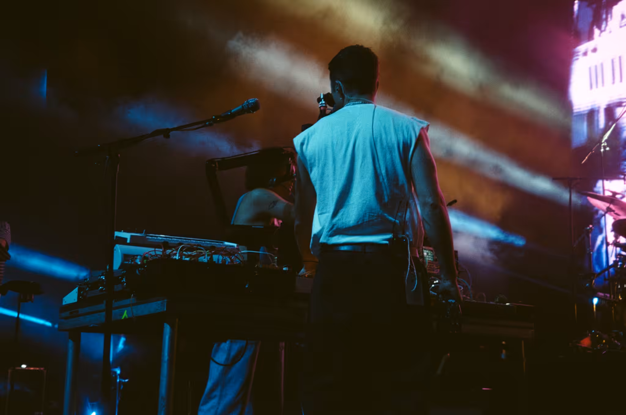 King Gizzard and the Lizard Wizard member at a synth rig in colored stage light, Phoenix