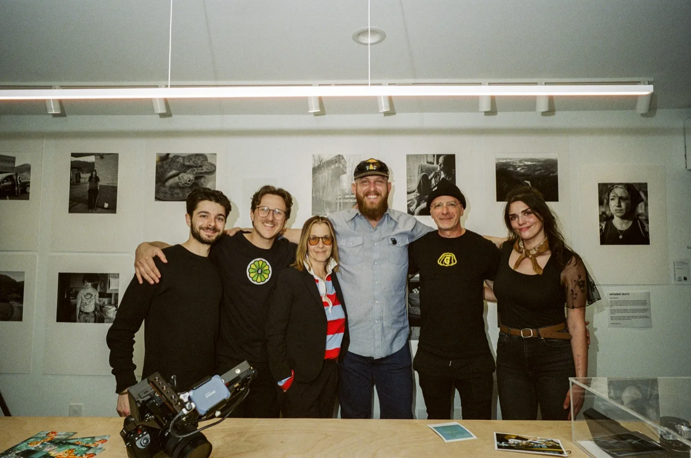 Francesco Aglieri Rinella with the Gelatin crew at the Apparent Death opening, large-format prints hung on the wall behind them.