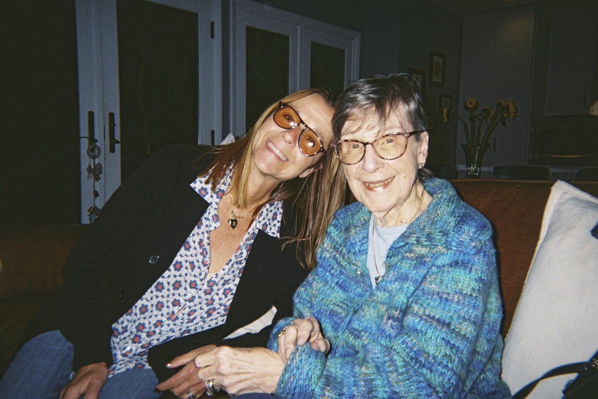 Two friends smiling on the couch, flash on, shot on a Gelatin disposable camera