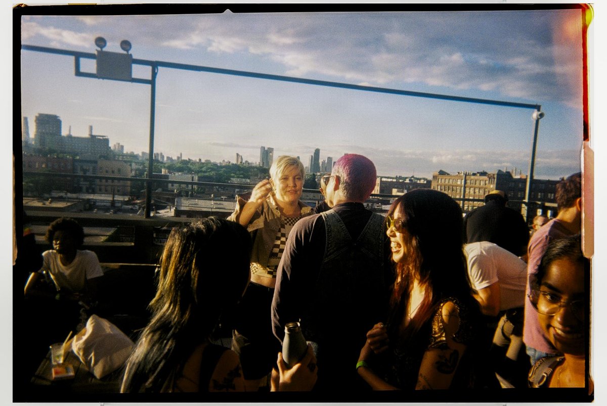 Rooftop party at golden hour, shot on a Gelatin disposable camera