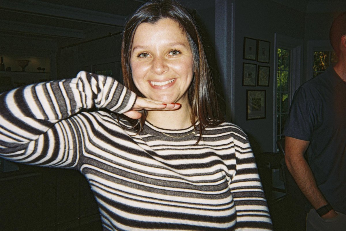 Flash portrait of a friend in a striped sweater, shot on a Gelatin disposable camera